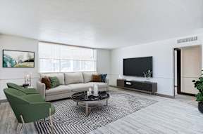 the living room of an apartment with a couch and a tv