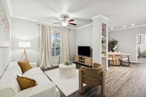 A living room with a white couch, a brown chair, and a television.