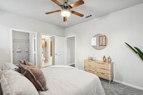 A bedroom with a bed, dresser, and mirror.