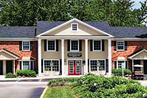A leasing office building with a red door and golf cart.
