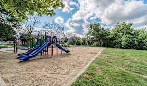 A playground with a blue slide and a red structure.