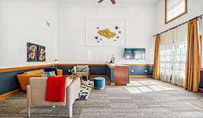 A living room with a blue accent wall and a ceiling fan.
