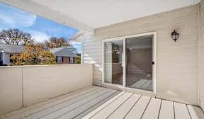 A balcony with a glass door and a black lantern on the wall.