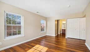 A room with wooden floors and a white door.