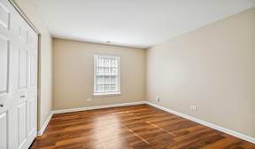 A room with wooden floors and a white door.