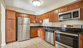 A kitchen with wooden cabinets and stainless steel appliances.