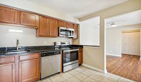 A kitchen with wooden cabinets and black countertops.