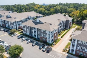 an aerial view of an apartment complex with cars parked in a parking lot