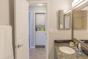a bathroom with a sink and a mirror and a closet
