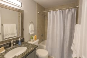 a bathroom with a sink toilet and shower and a mirror