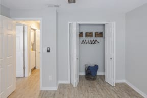 a hallway with two closets and a basket on the floor