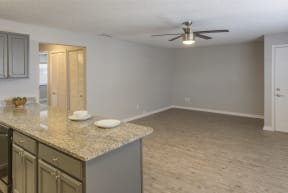an empty kitchen and living room with a ceiling fan