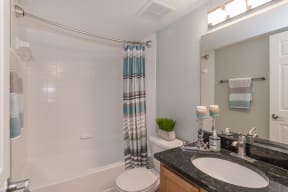 a bathroom with a shower and a sink and a toilet