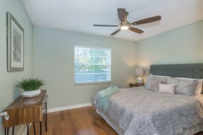 the master bedroom has a large bed and a ceiling fan