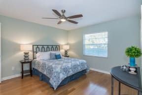 the master bedroom has a large bed and a ceiling fan