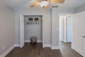 a hallway with a closet and a ceiling fan