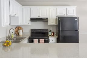a kitchen with black appliances and white cabinets