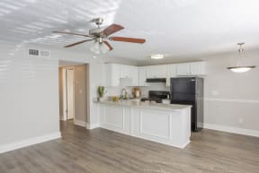a kitchen with a large island and a ceiling fan