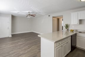 an empty kitchen and living room with a ceiling fan