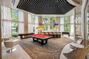 a billiards table in a room with windows