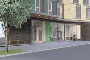 A modern building with a green sign on the door.