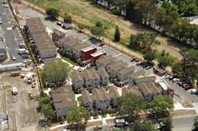 A large apartment complex with a parking lot in front.