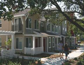 A couple walking in front of a row of houses.