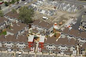 A construction site is surrounded by apartment buildings.