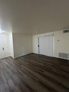 A room with a white door and a window with blinds.