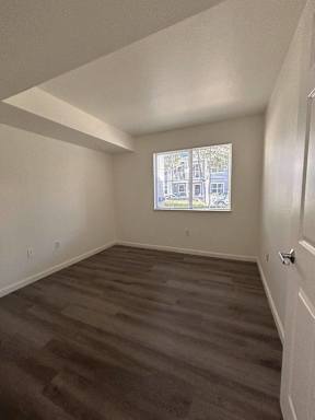 A room with a window showing a view of a building outside.