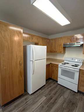 A kitchen with a white refrigerator and a white stove top oven.