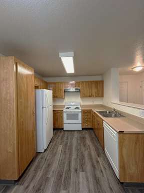 A kitchen with wooden cabinets and white appliances.