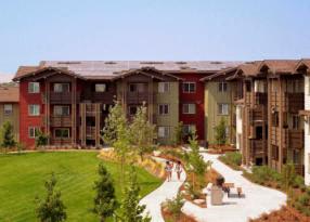 A large apartment complex with a green lawn in front.