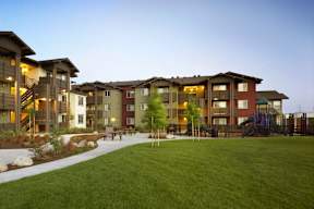 Apartment complex with a green lawn in front.