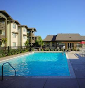 A swimming pool in front of apartment buildings.