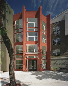 A red building with a tree in front of it.