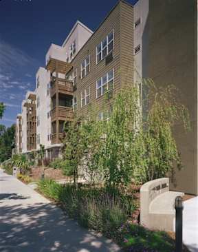 A modern building with a curved design and a balcony on the second floor.