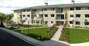 Apartment building with a green lawn in front.