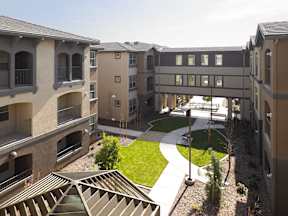 Apartment complex with a green space in the middle.