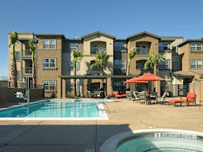 A large apartment complex with a pool and patio area.