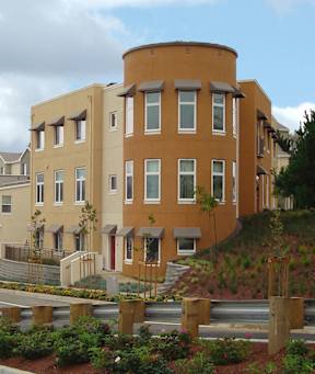 A brown building with a curved top and a red door.
