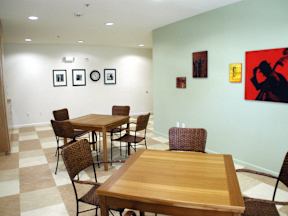 A room with a table and chairs and pictures on the wall.