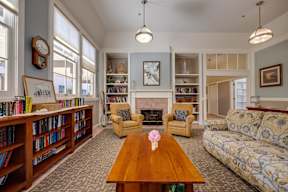 A living room with a fireplace, bookshelves, and a couch.