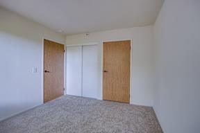 A room with two doors and carpeted floor.