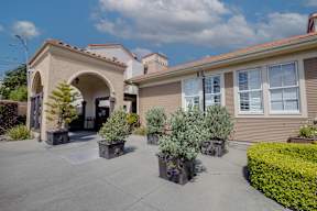 A house with a white archway entrance and a grey roof.