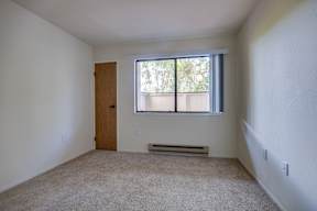 A room with a brown door and a window with blinds.