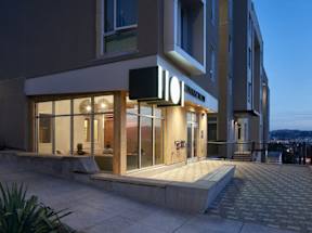 A modern hotel with a lit up sign on the front.