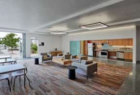 A modern open plan living and dining area with a kitchen in the background.
