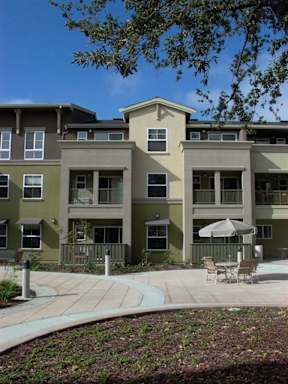 Apartment complex with a patio and chairs.