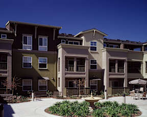 Apartment complex with a courtyard in front.